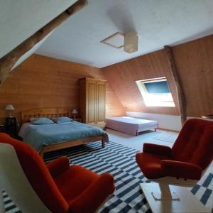 a bedroom with a bed and two chairs at Chambre des bords de Siame in Gratot