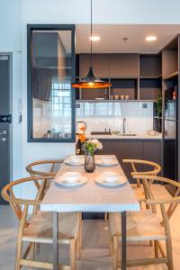a kitchen with a wooden table and chairs at Novo Kuala Lumpur by Cobnb, Jalan Ampang in Kuala Lumpur
