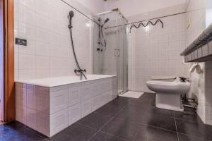 a white bathroom with a shower and a toilet at Historic City and 3 Bedrooms - Centre Lake Apartment in Pisogne