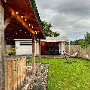 un cortile con pergolato in legno e sedia di Well c Home gîte bien-être a Mons