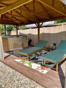 due tavoli da picnic su una terrazza sotto un gazebo di Well c Home gîte bien-être a Mons