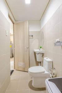 a white bathroom with a toilet and a sink at Luxurious Bayview 2BR Near MOA PICC CCP Free WiFi in Pasay in Manila