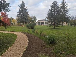 einen Garten mit Bäumen und ein Haus im Hintergrund in der Unterkunft L' Évasion en plein air in Fontenay-sur-Loing + 3 Fotos