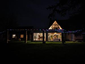 ein nachts beleuchtetes Haus mit Weihnachtsbeleuchtung in der Unterkunft L' Évasion en plein air in Fontenay-sur-Loing