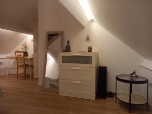 ein Zimmer mit einer Kommode und einem Tisch in einem Zimmer in der Unterkunft L' Évasion en plein air in Fontenay-sur-Loing