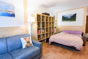 a living room with a blue couch and a bed at Appartamento La Valeille in Cogne