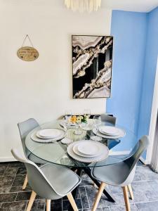 a dining room with a glass table and chairs at Home away from home in Mile End