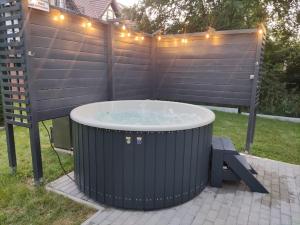 a hot tub in a backyard with a fence at Dom na Zadzielu - domek z balią nad Jeziorem Żywieckim in Żywiec