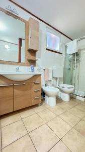 a bathroom with a sink and a toilet and a shower at Onda Marina Apartments in Ischia