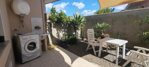 a patio with a washing machine and a table and chairs at Cla House in Assemini
