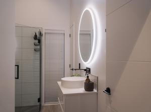 a white bathroom with a sink and a mirror at Boutique One Bedroom Haven in Wanaka