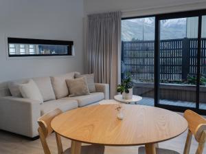 a living room with a table and a couch at Boutique One Bedroom Haven in Wanaka
