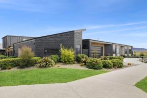 a brick house with a garden in front of it at Boutique One Bedroom Haven in Wanaka