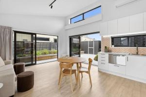 a kitchen and living room with a table and chairs at Boutique One Bedroom Haven in Wanaka