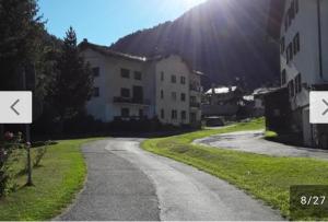 a winding road in front of a white building at Appartamento La Valeille in Cogne