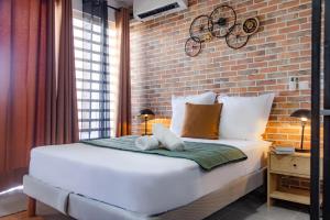 a bed in a room with a brick wall at Le Loft industriel à la Zac Hibiscus - Terrasse in Trou Biron