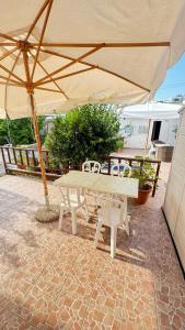 a table and chairs under an umbrella on a patio at Onda Marina Apartments in Ischia +45 photos