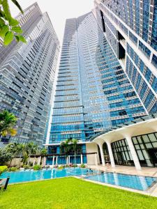 a large building with a pool in front of two tall buildings at Uptown Parksuites BGC with Balcony in Manila