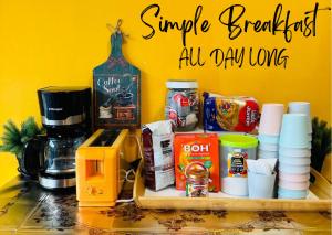 a counter top with a coffee maker and some food at The Cocoon Capsule Hotel in Cameron Highlands