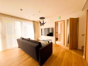 a living room with a couch and a television at Niseko White Villas1 in Niseko
