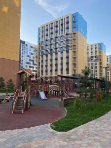 a playground in front of a large building at Contento Apartments in Almaty