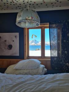 a bedroom with a bed and a window with a polar bear at Peaceful property with spectacular sea view in Leknes