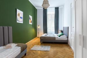 two beds in a room with green walls at Wonderful Apartments in the Center of Krakow in Kraków