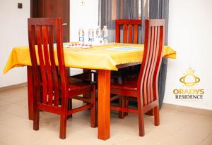a dining room table with two chairs and a yellow table cloth at ORADYS Residence in Sanguéra