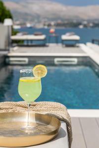 una bebida sentada en una bandeja junto a una piscina en Villa palace al Nera 2 Luxurius at sea, en Trogir