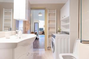 La salle de bains blanche est pourvue d'un lavabo et d'un lave-linge. dans l'établissement Vintage Charm Apt near Centre, à Héraklion 19 autres photos