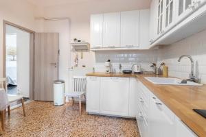 une cuisine blanche avec un évier et un comptoir dans l'établissement Vintage Charm Apt near Centre, à Héraklion