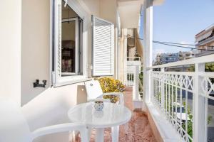 une table blanche et des chaises sur un balcon dans l'établissement Vintage Charm Apt near Centre, à Héraklion