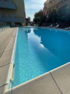 een groot blauw zwembad in een gebouw bij Apartament Mare e Sole z basenem i przy plaży in Marotta +22 foto's