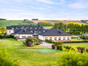 a large house with a golf green in the yard at Dosłońce Resort Wellness & Farm in Racławice