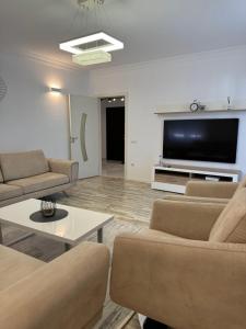 a living room with couches and a flat screen tv at Penthouse Exclusive in Pristina