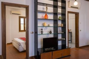 una sala de estar con TV y una habitación con cama en ht vicolo 6 bilo, en Roma