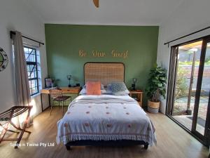 a bedroom with a bed with a be our guest sign on the wall at Harbour Delight & Harbour Comfort in Cape Town