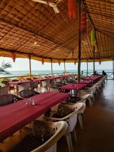 a row of tables and chairs in a restaurant at Dunes Holiday Village in Mandrem