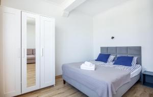 1 dormitorio con cama con almohadas azules y espejo en Beautiful Apartment In Jastarnia, en Jastarnia