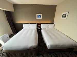 釧路市にあるANAクラウンプラザホテル釧路の部屋に並んで置かれた2つのベッド +91枚の写真