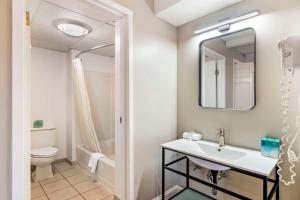 a bathroom with a sink and a toilet and a mirror at Black Bear Inn, an Ascend Collection Hotel in Orono +32 photos