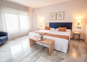 um quarto de hotel com duas camas e uma mesa em First Flatotel International em Benalmádena