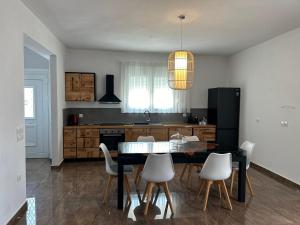 a kitchen with a black table and white chairs at Villa Ellania Milos in Adamantas
