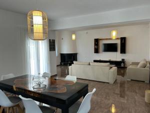 a living room with a black table and white chairs at Villa Ellania Milos in Adamantas