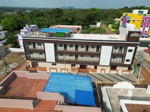an overhead view of a building with a swimming pool at Magan Enclave in Kuttālam