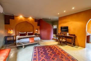 a bedroom with a bed and a desk and a television at Singa Lodge - Lion Roars Hotels & Lodges in Port Elizabeth