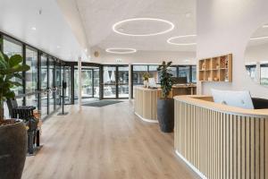 an office lobby with a reception desk and windows at Best Western Plus Hotel Odense in Odense