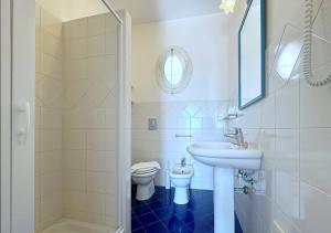 a white bathroom with a sink and a toilet at Solemar Sicilia - Palazzo Eos e Aura in Porticello +14 photos