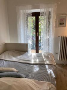 un grand lit dans une chambre avec une fenêtre dans l'établissement La casa in collina, à Bellagio