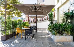 a patio with tables and chairs and an umbrella at Hotel El Toro Tanger in Tangier